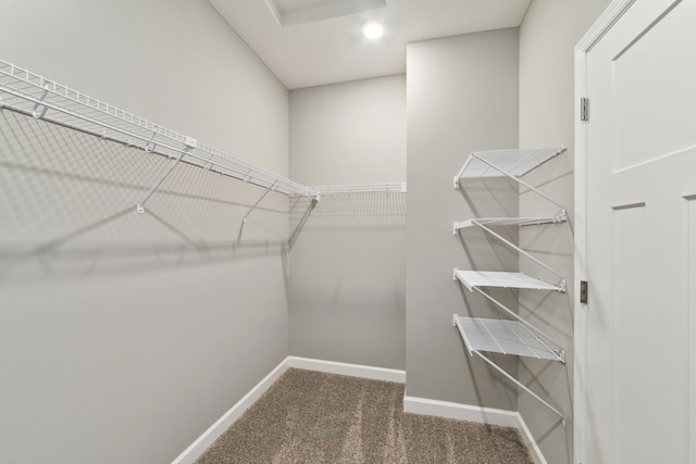 spacious closet with dark carpet