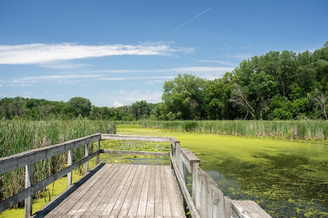 wooden deck with a water view and a yard