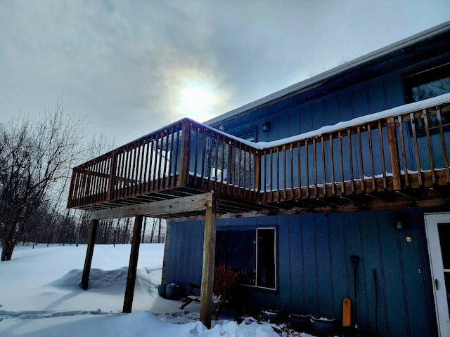 view of snowy exterior with a wooden deck