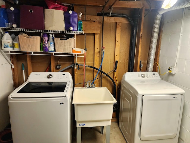 clothes washing area with washing machine and dryer and sink