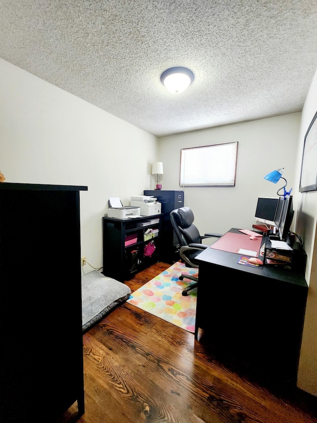 home office featuring dark wood-type flooring and a textured ceiling