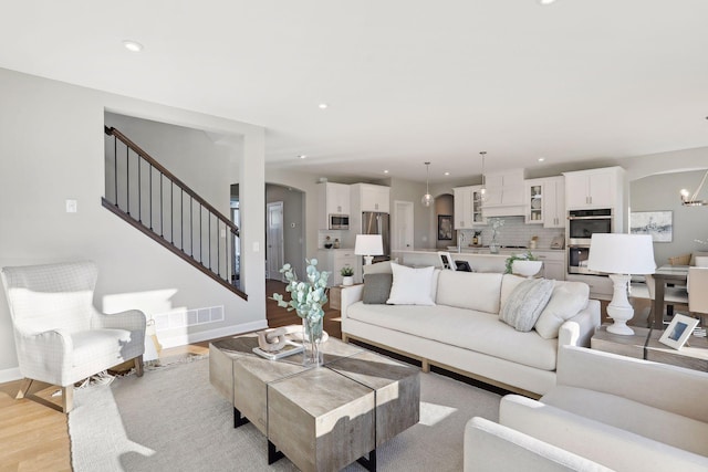 living room featuring a chandelier and light wood-type flooring