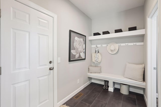 mudroom with dark tile patterned flooring