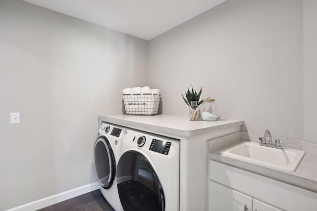 clothes washing area featuring cabinets, washing machine and dryer, sink, and dark tile patterned floors