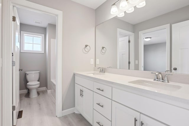 bathroom featuring vanity, hardwood / wood-style floors, and toilet