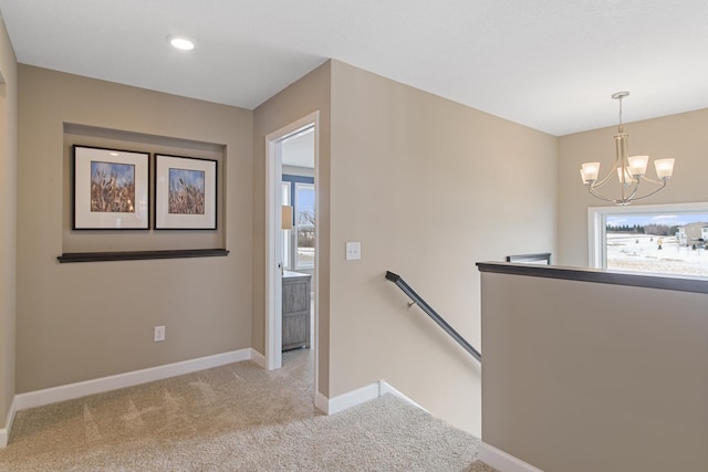 stairway with carpet flooring and a chandelier