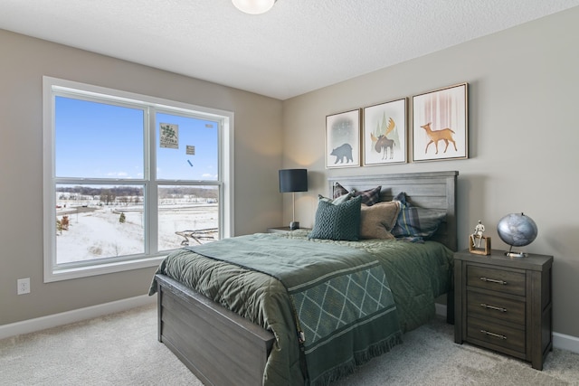 bedroom featuring light colored carpet and a textured ceiling