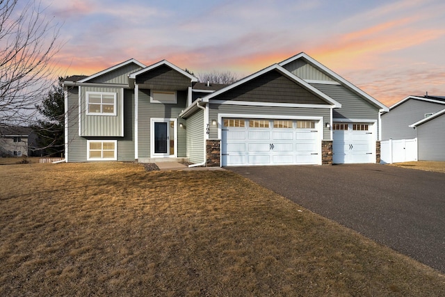 view of front of house with driveway, fence, board and batten siding, a front yard, and a garage