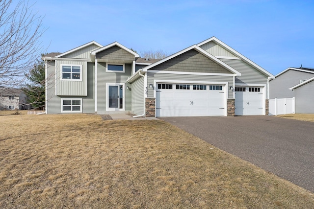 craftsman inspired home featuring driveway, fence, board and batten siding, a front yard, and an attached garage