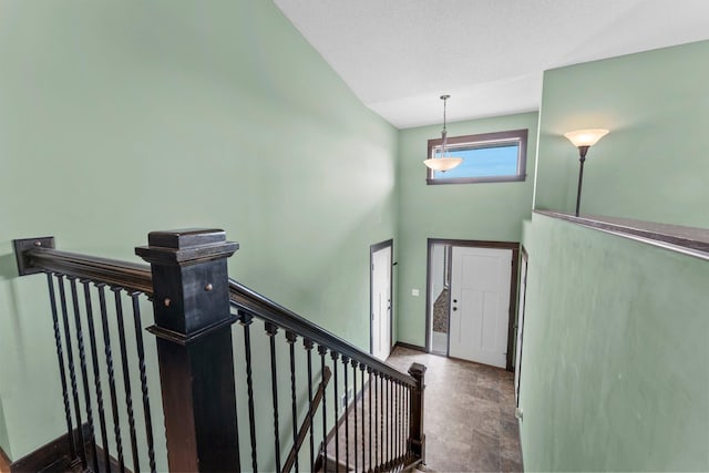 staircase featuring baseboards and a towering ceiling