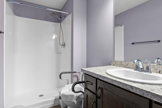 bathroom with a shower stall, vanity, and toilet