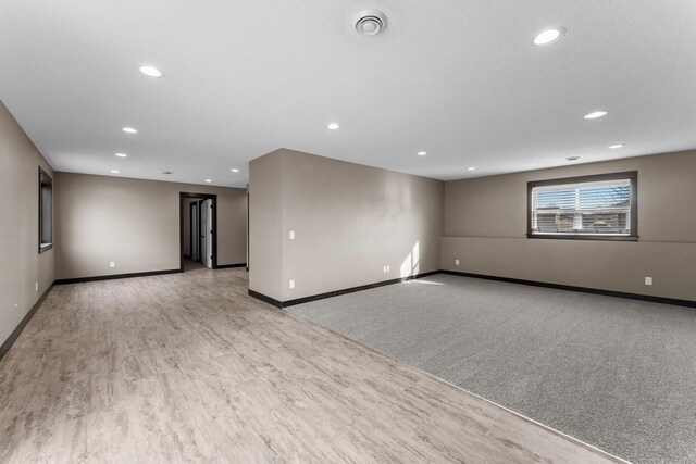 unfurnished room with visible vents, recessed lighting, light wood-style floors, and baseboards