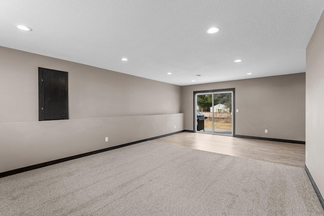 spare room featuring recessed lighting, baseboards, carpet floors, and a textured ceiling