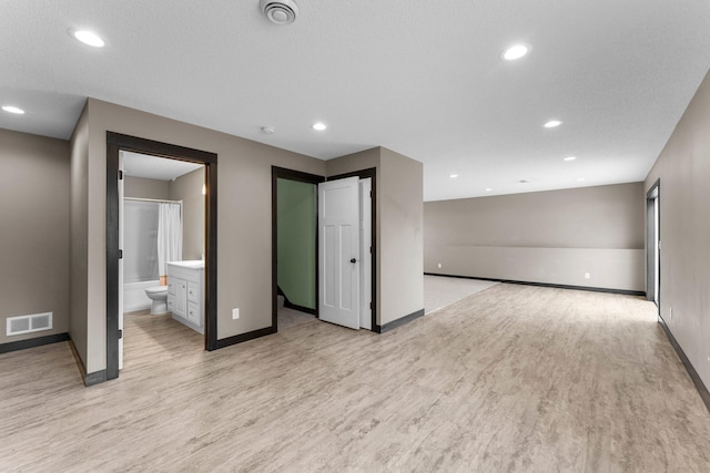 interior space with visible vents, baseboards, recessed lighting, light wood-style floors, and a textured ceiling