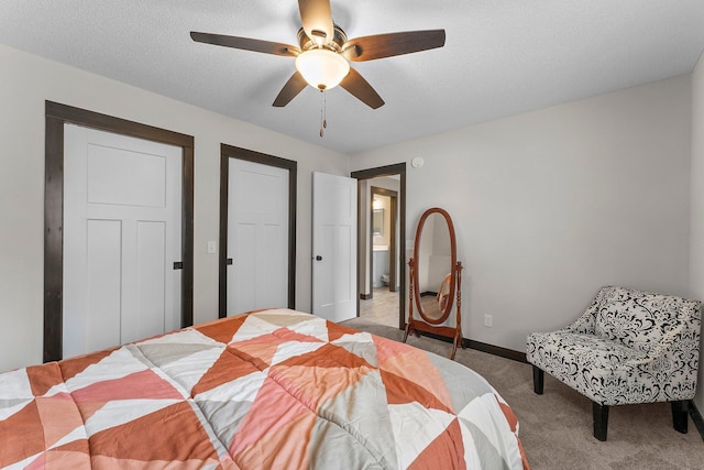 bedroom featuring light carpet, ceiling fan, a textured ceiling, and baseboards