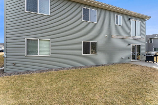 rear view of property featuring a patio area and a lawn