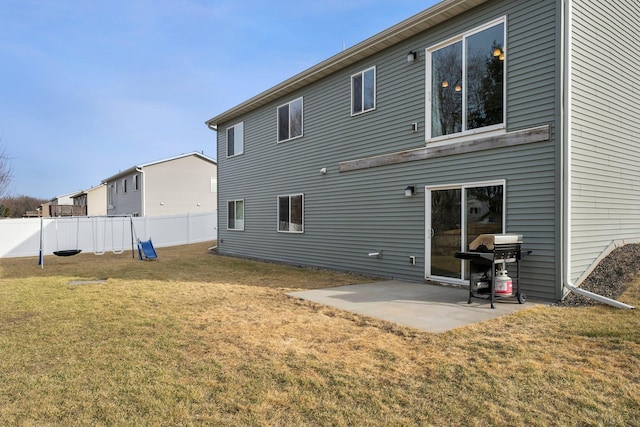 rear view of property with a yard, a patio, and fence