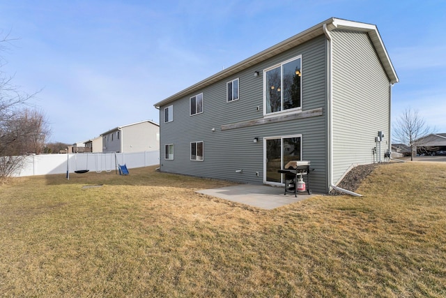 rear view of house featuring a patio, a yard, and fence