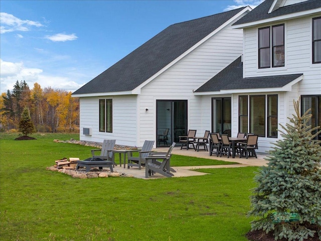 rear view of property with a yard, a patio area, and an outdoor fire pit