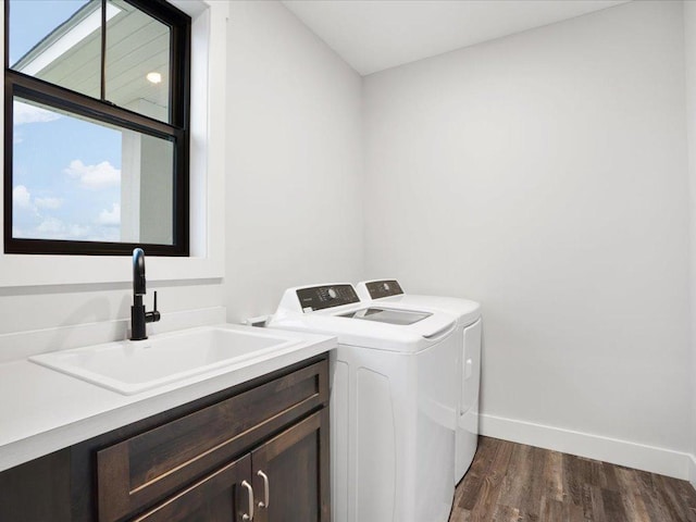 washroom featuring dark wood-type flooring, cabinets, sink, and washing machine and dryer