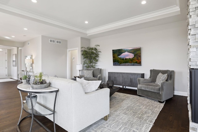 living room featuring a raised ceiling, crown molding, and hardwood / wood-style floors