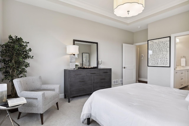 carpeted bedroom featuring connected bathroom and a tray ceiling