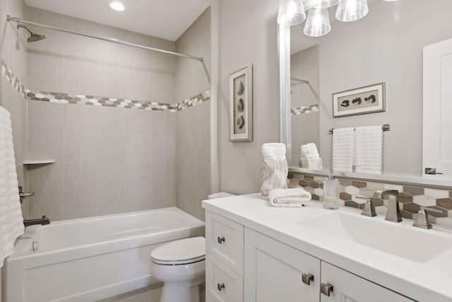 full bathroom with tasteful backsplash, vanity, tiled shower / bath combo, and toilet