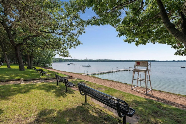 dock area with a lawn and a water view