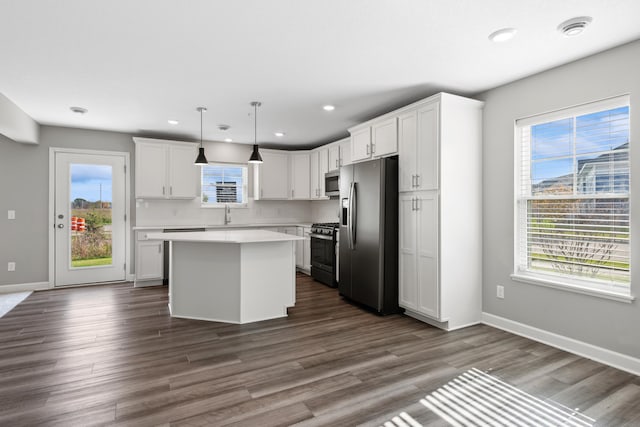 kitchen with white cabinetry, hanging light fixtures, stainless steel appliances, a center island, and a healthy amount of sunlight