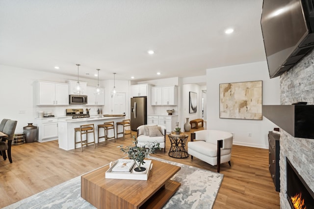 living room with a fireplace and light wood-type flooring