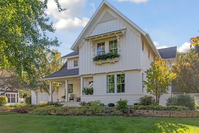 modern inspired farmhouse with covered porch, board and batten siding, a front lawn, and roof with shingles