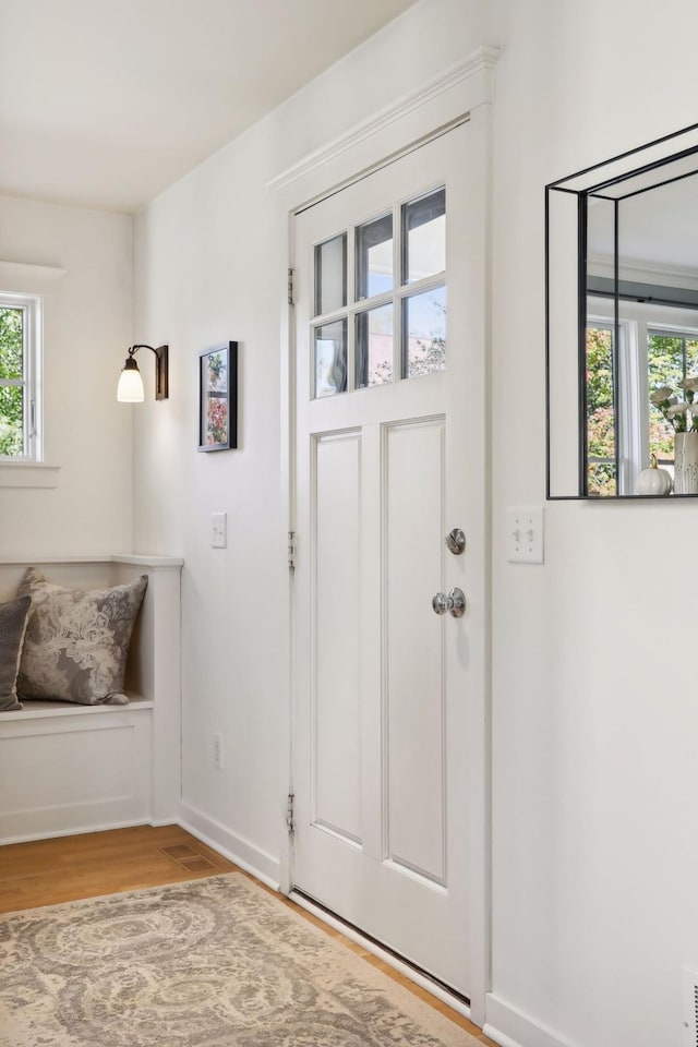 foyer entrance featuring baseboards and wood finished floors