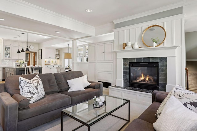 carpeted living area featuring recessed lighting, a fireplace, and crown molding