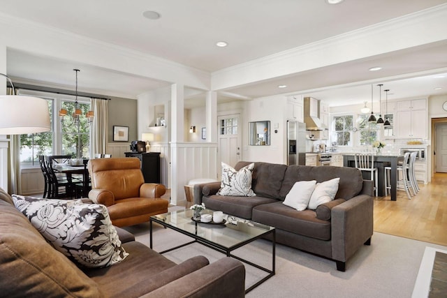 living room with recessed lighting, wainscoting, crown molding, and light wood-style floors