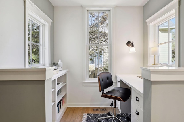 home office featuring visible vents, baseboards, and wood finished floors