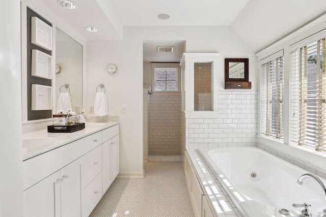 bathroom with visible vents, a jetted tub, and a healthy amount of sunlight