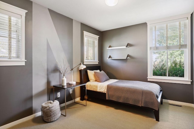 carpeted bedroom with visible vents and baseboards