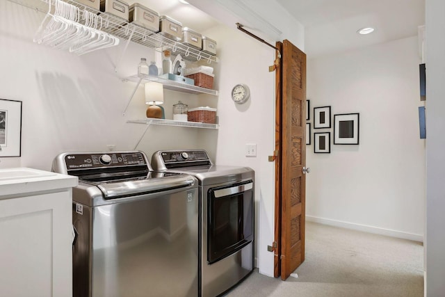 clothes washing area with baseboards, washer and clothes dryer, light colored carpet, laundry area, and recessed lighting