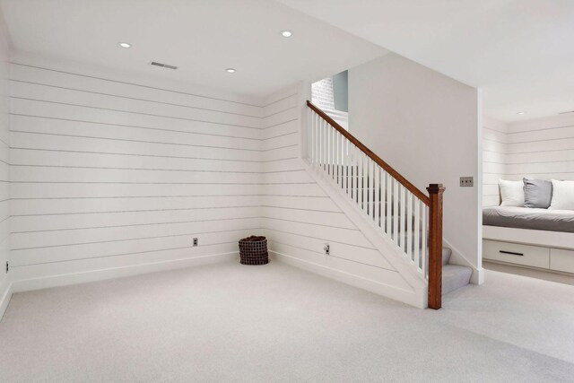 stairs featuring recessed lighting, visible vents, carpet floors, and wood walls