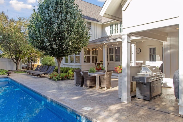 view of swimming pool with outdoor dining area, fence, a grill, a fenced in pool, and a patio area