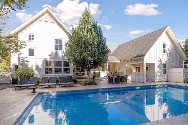 outdoor pool with a patio and fence