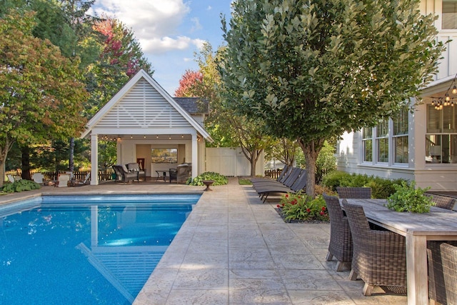 pool with a gazebo, a patio, outdoor dining space, and fence