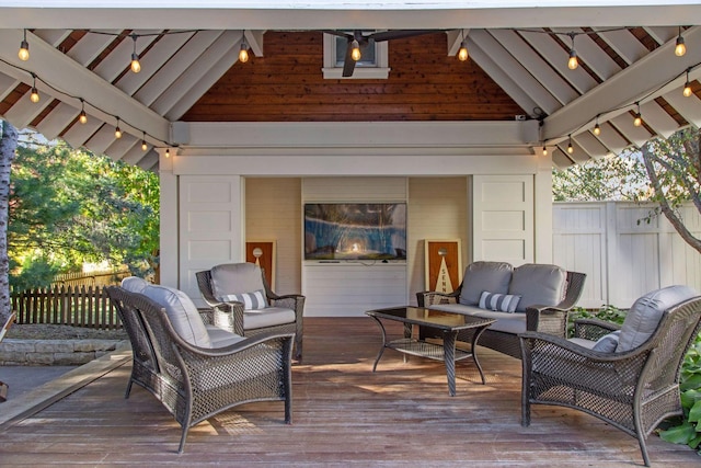 wooden terrace with an outdoor living space and fence