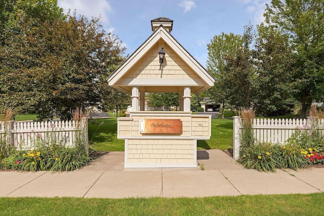 view of property's community with a yard and fence