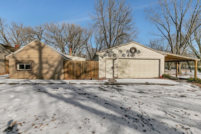 snow covered garage with a carport