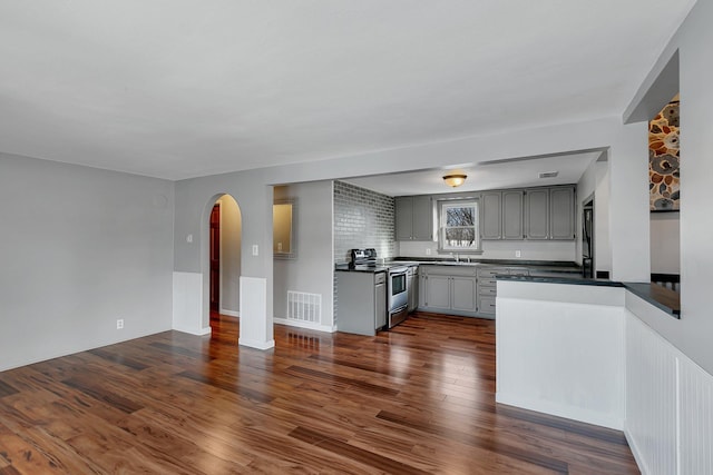 kitchen with sink, dark wood-type flooring, gray cabinetry, and electric range