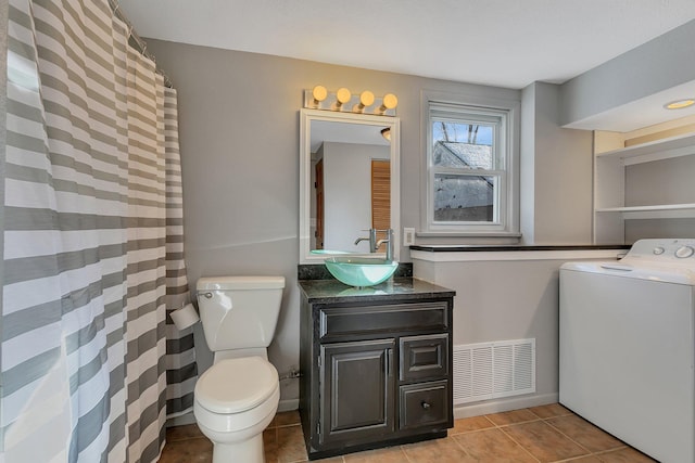 bathroom with vanity, toilet, washer / dryer, and tile patterned flooring