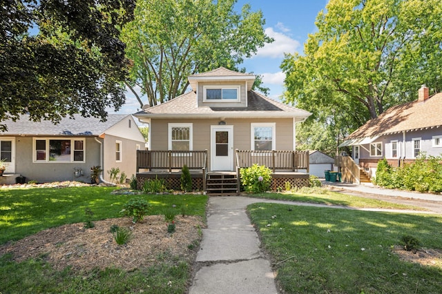 bungalow-style house featuring a wooden deck and a front lawn