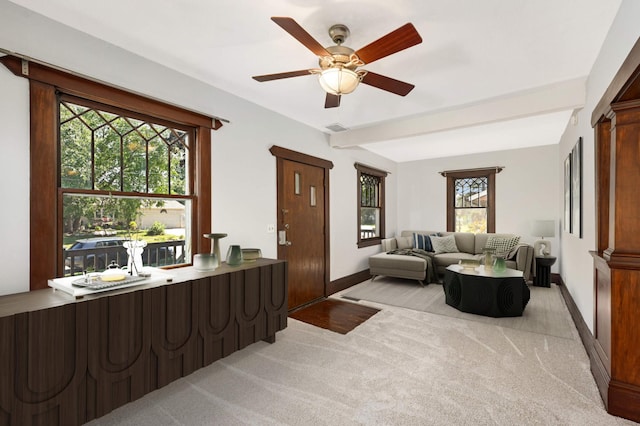 carpeted living room with beamed ceiling and ceiling fan