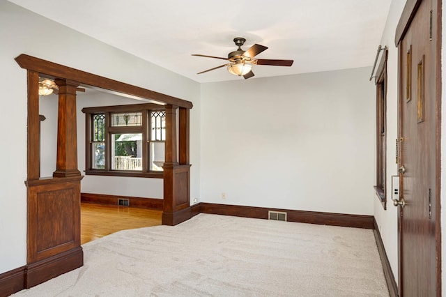 unfurnished room featuring ceiling fan and decorative columns